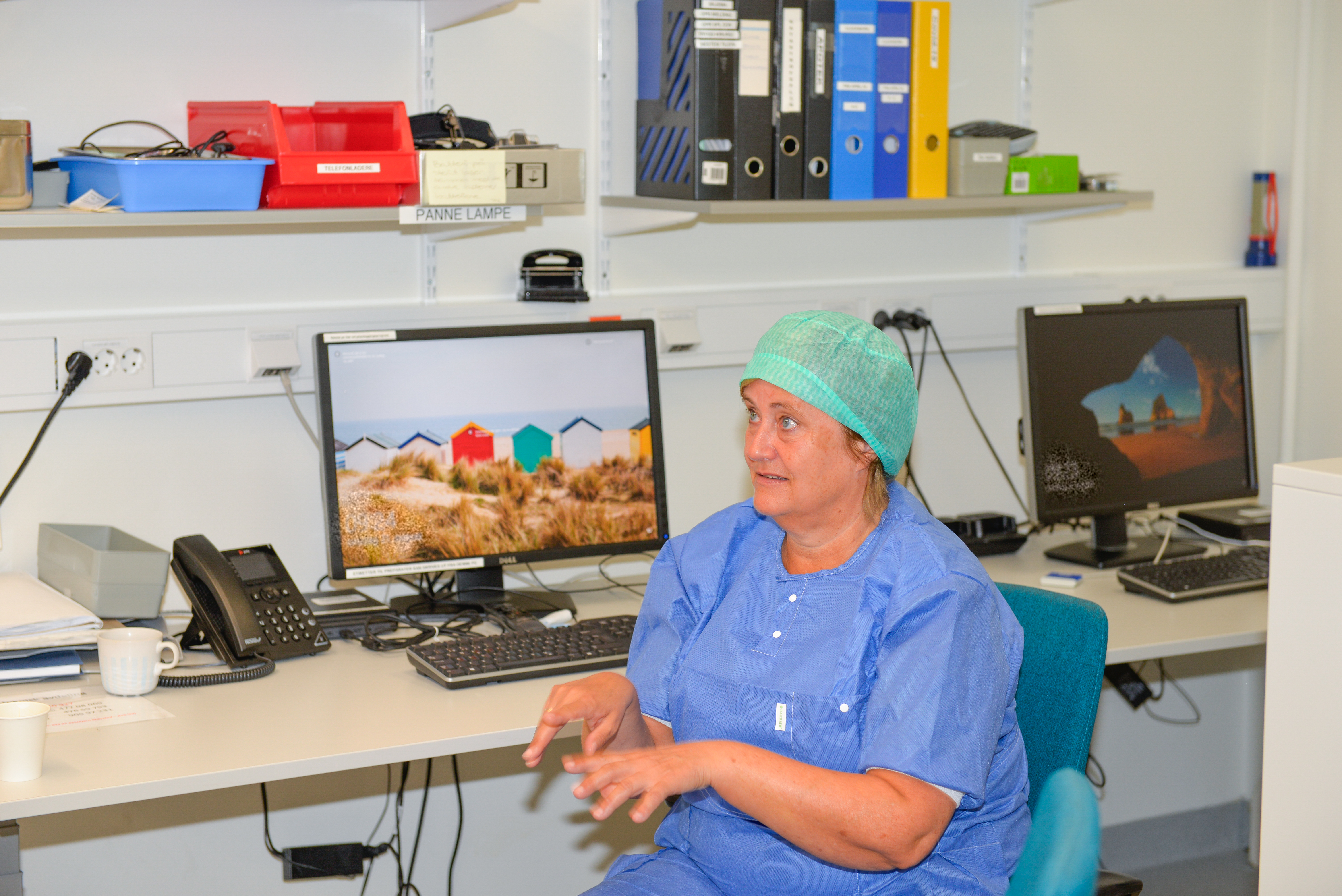 Dame i sykehusklær snakker og gestikulerer