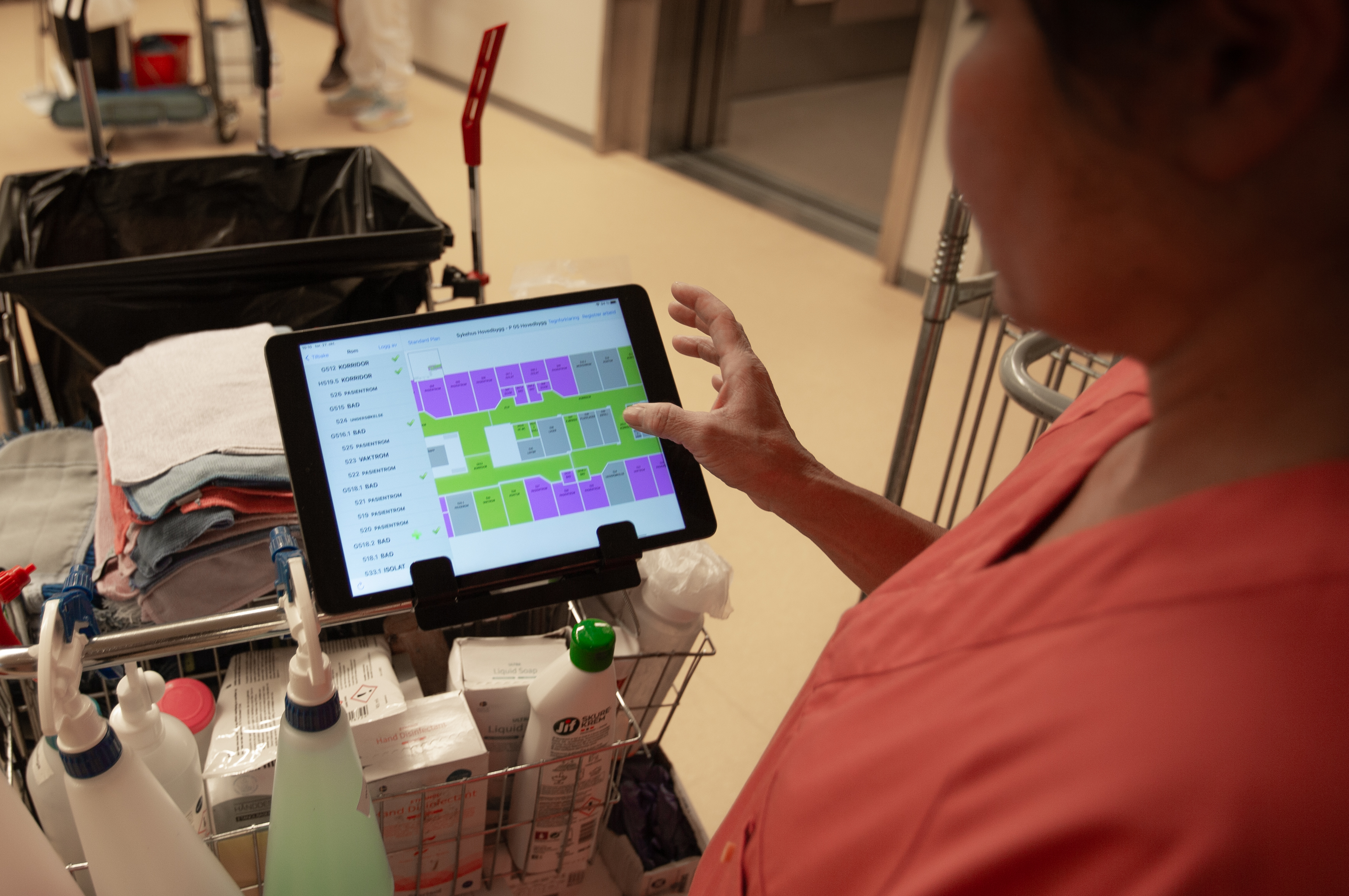 En renholder som holder oversikt over arbeidsoppgavene sine på en ipad