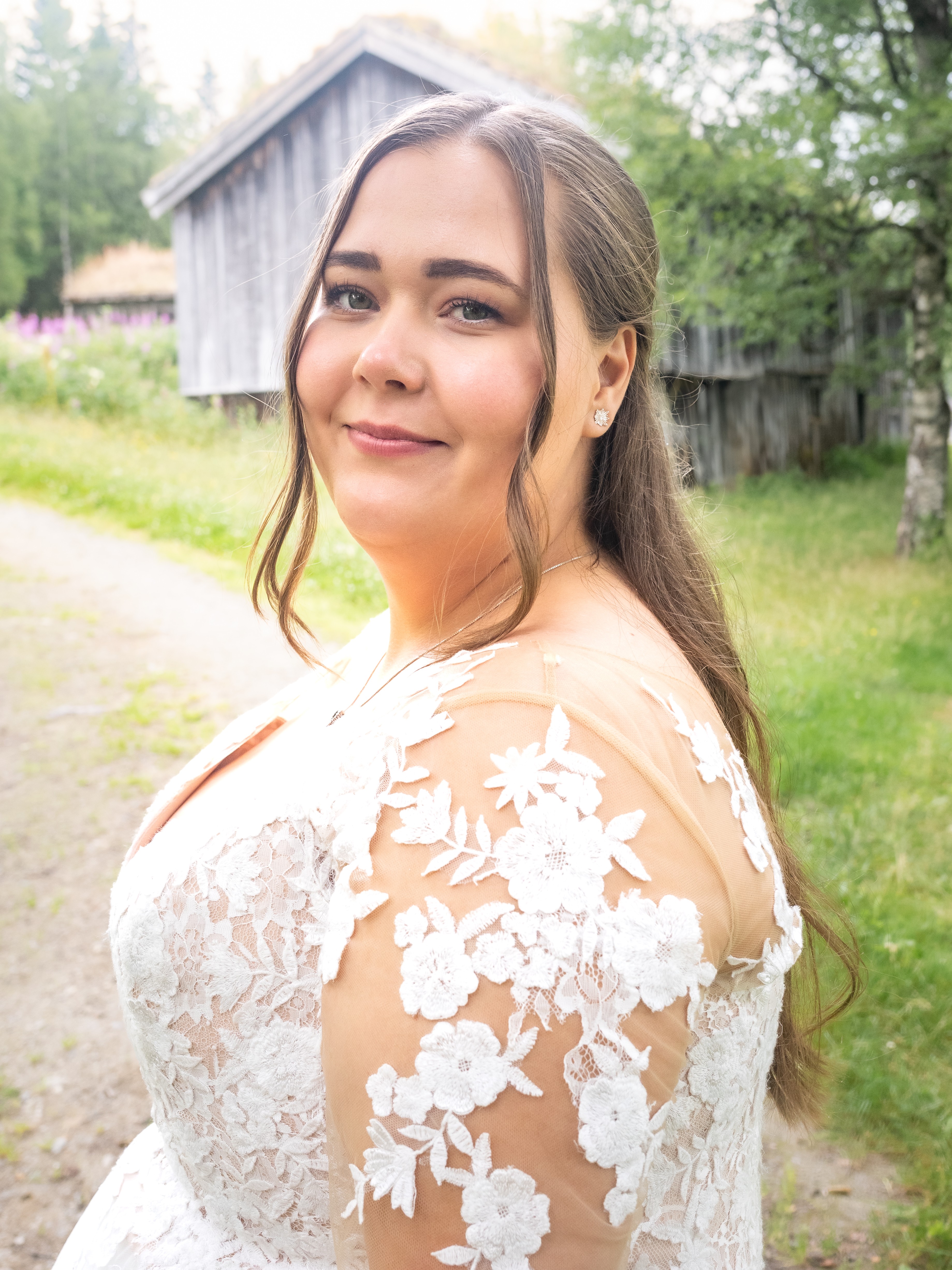 En dame i hvit kjole og langt hår snur seg mot kamera