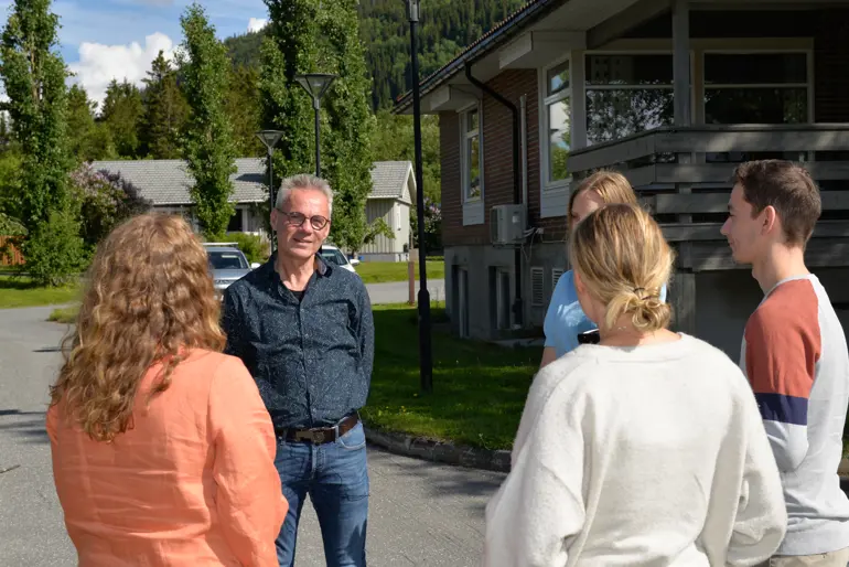 Fem kolleger står ute i sola og har en pause