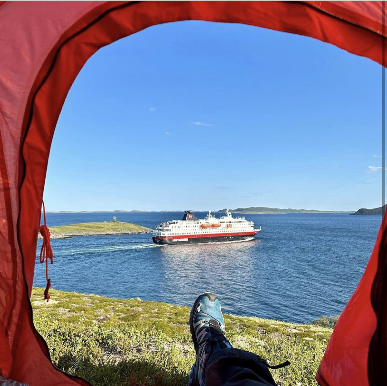Hurtigruta glir forbi mens en person ligger i et telt med ene foten ut, og ser på