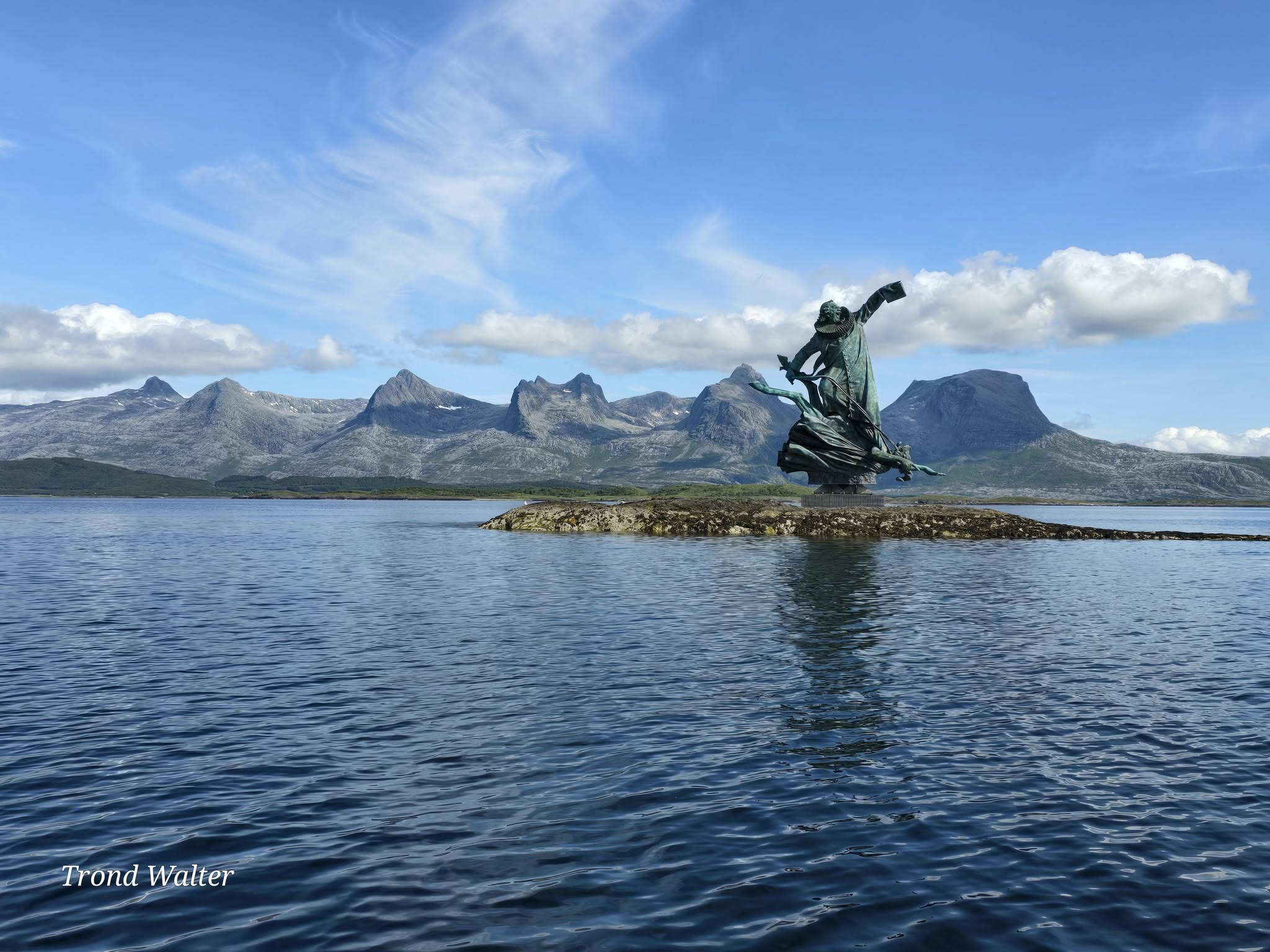 En statue på en øy midt i havet, statuen er av Petter dass