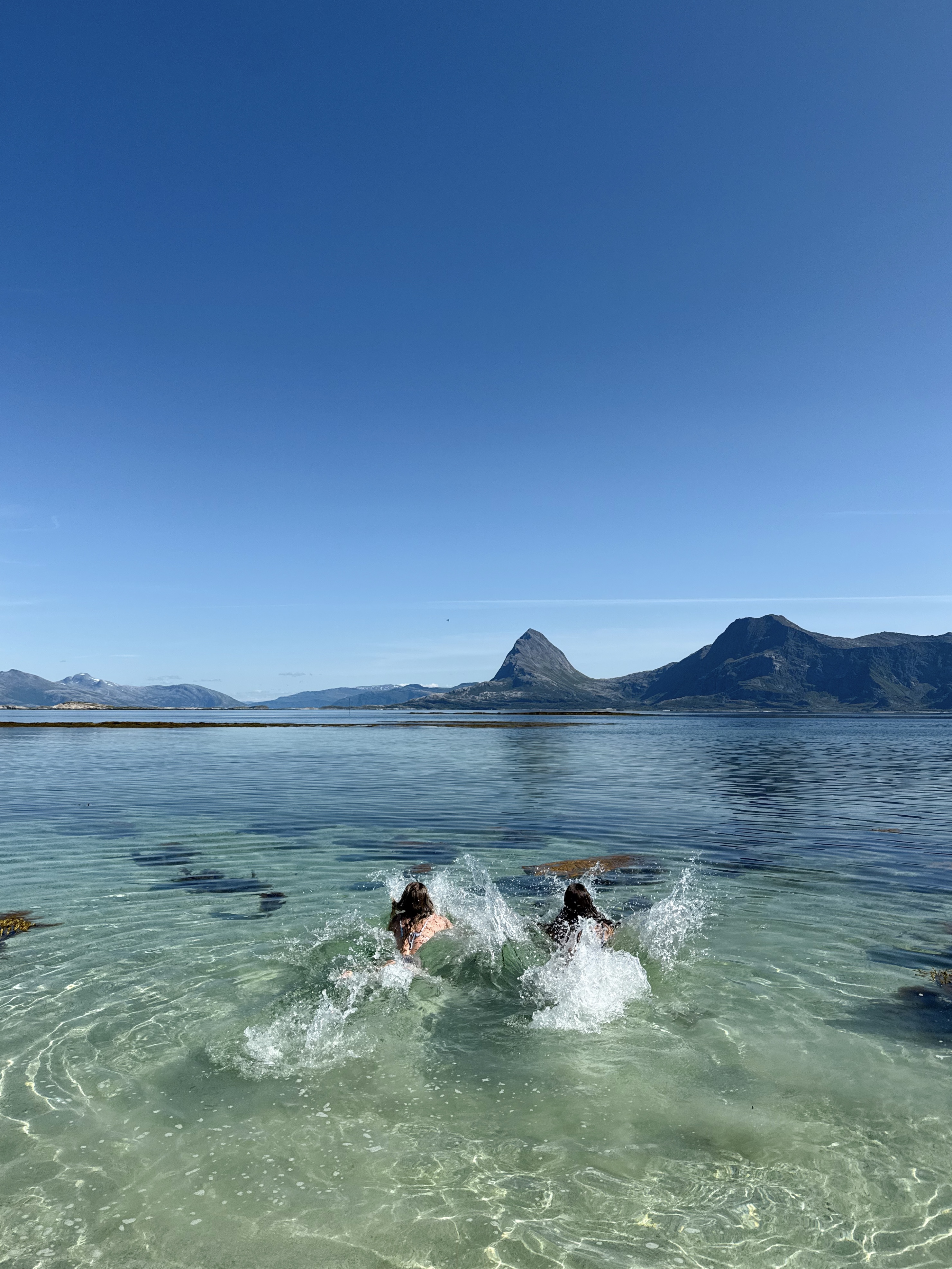 To personer kaster seg ut i havet for å bade