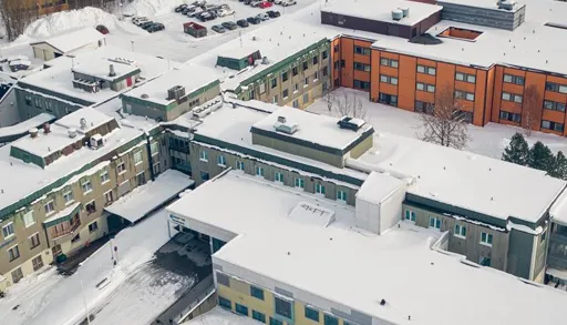 En bygning med parkeringsplass og snø på bakken