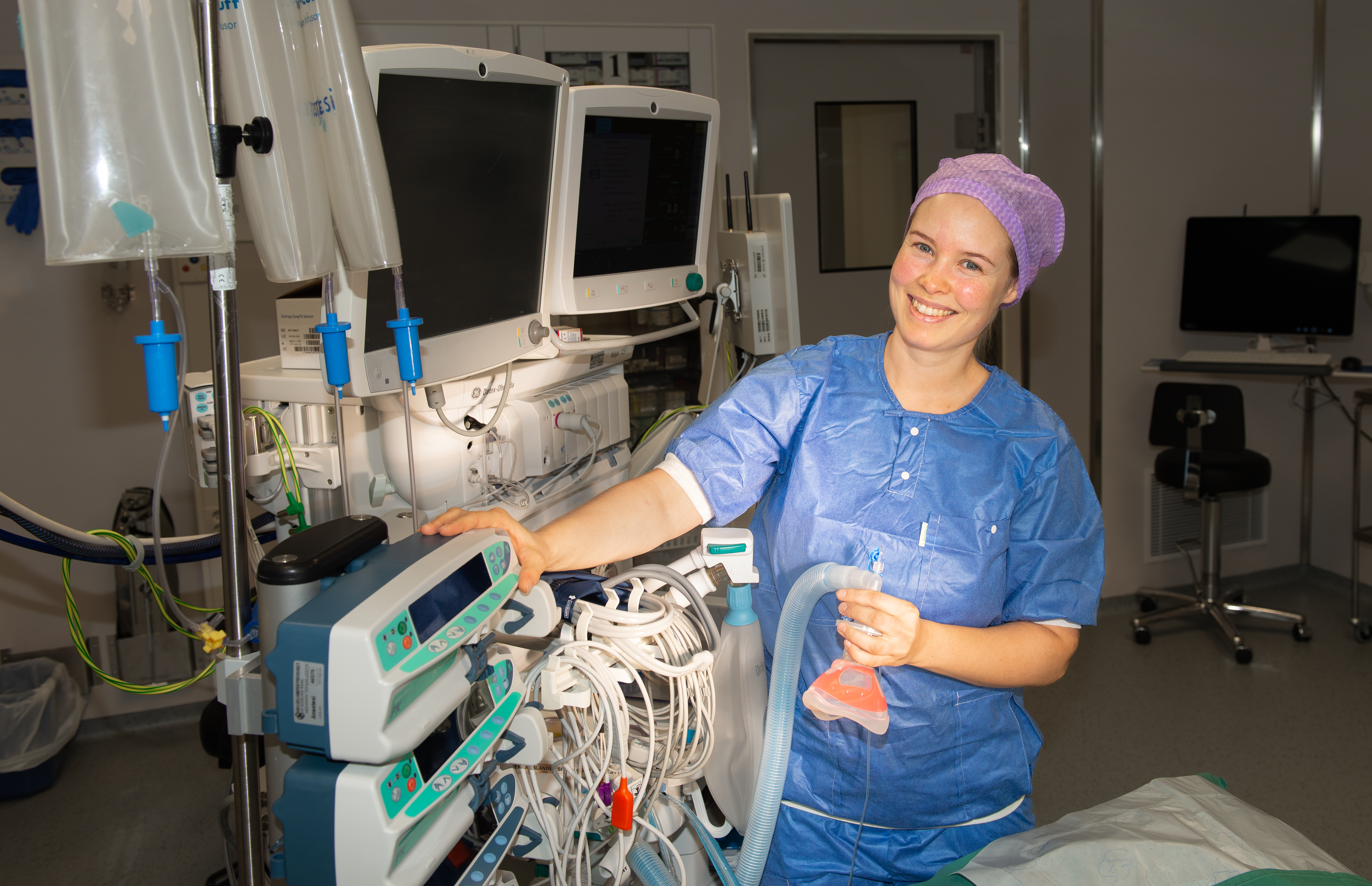 Dame viser fram ulikt utstyr i en operasjonssal.