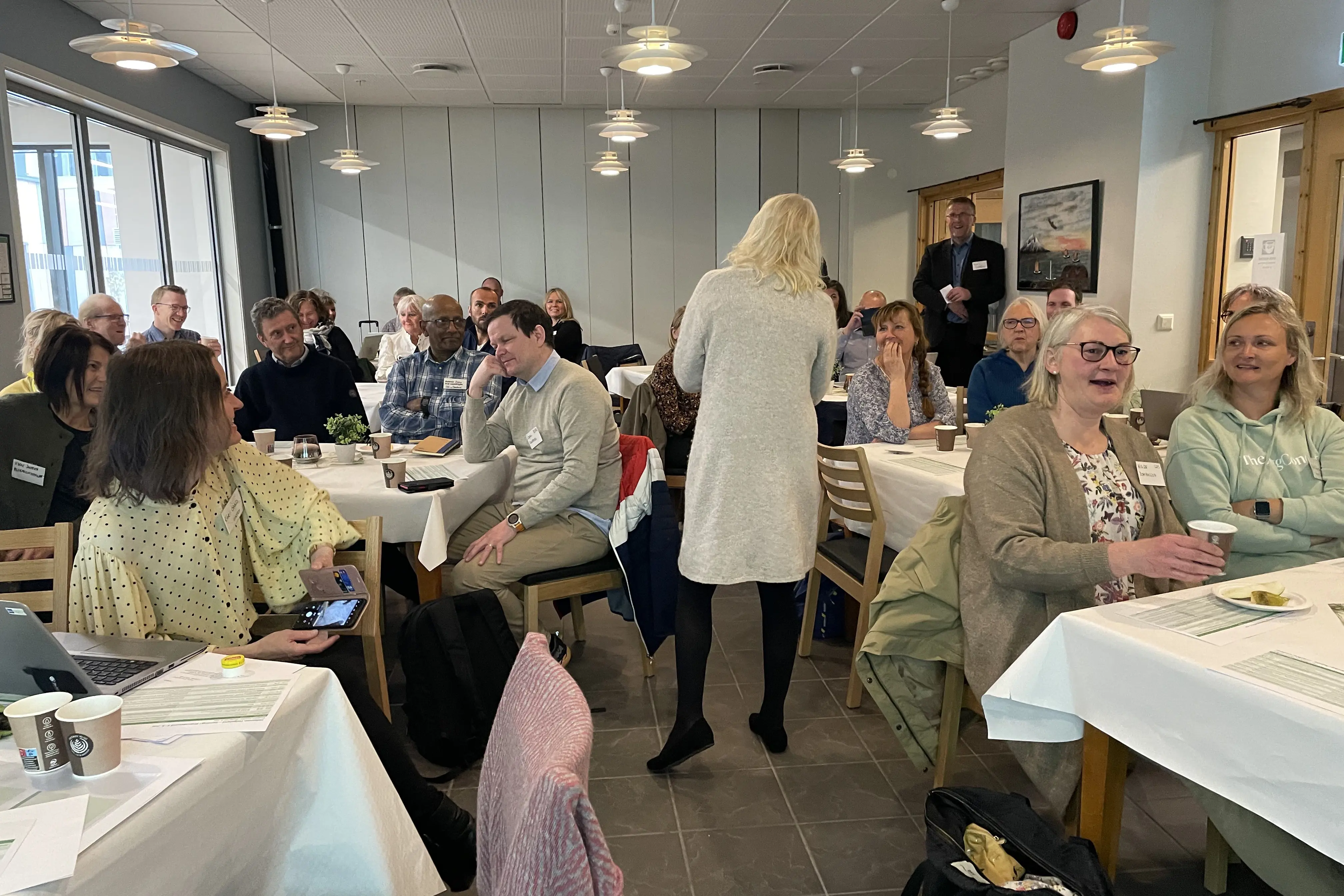 Mange leende personer i et lokale