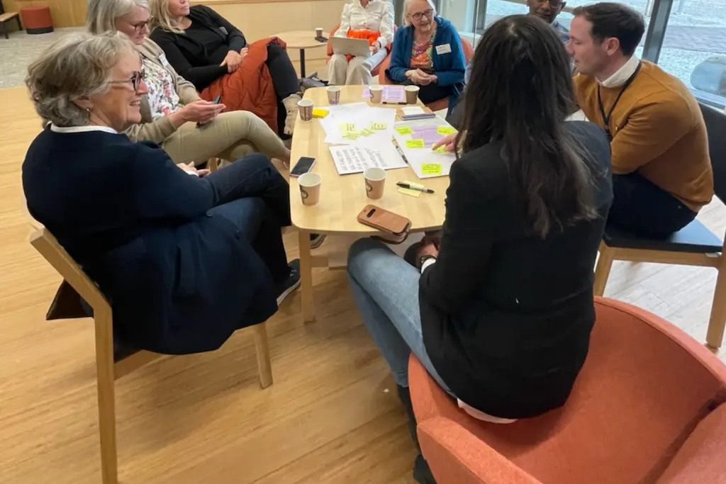 åtte personer snakker sammen