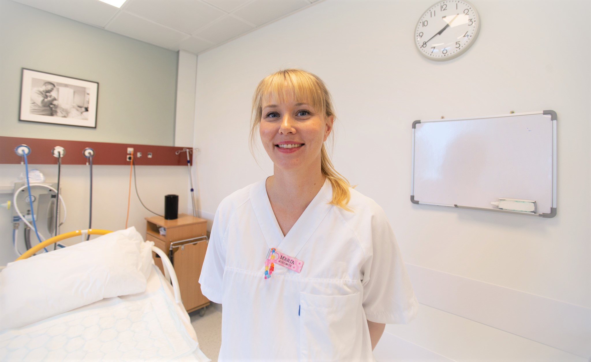 Dame i hvite klær smiler