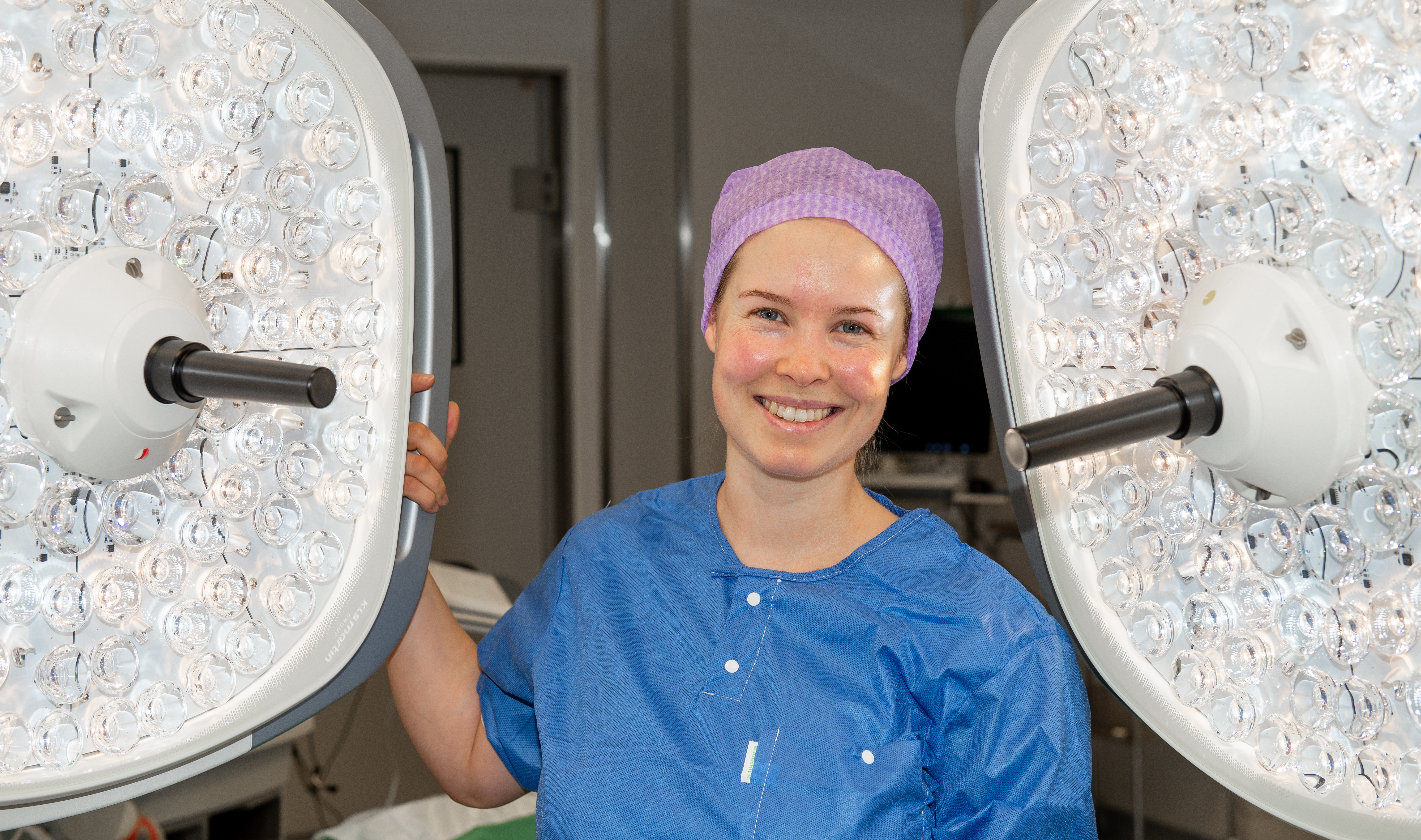 Dame holder i ei stor lampe i operasjonssalen.