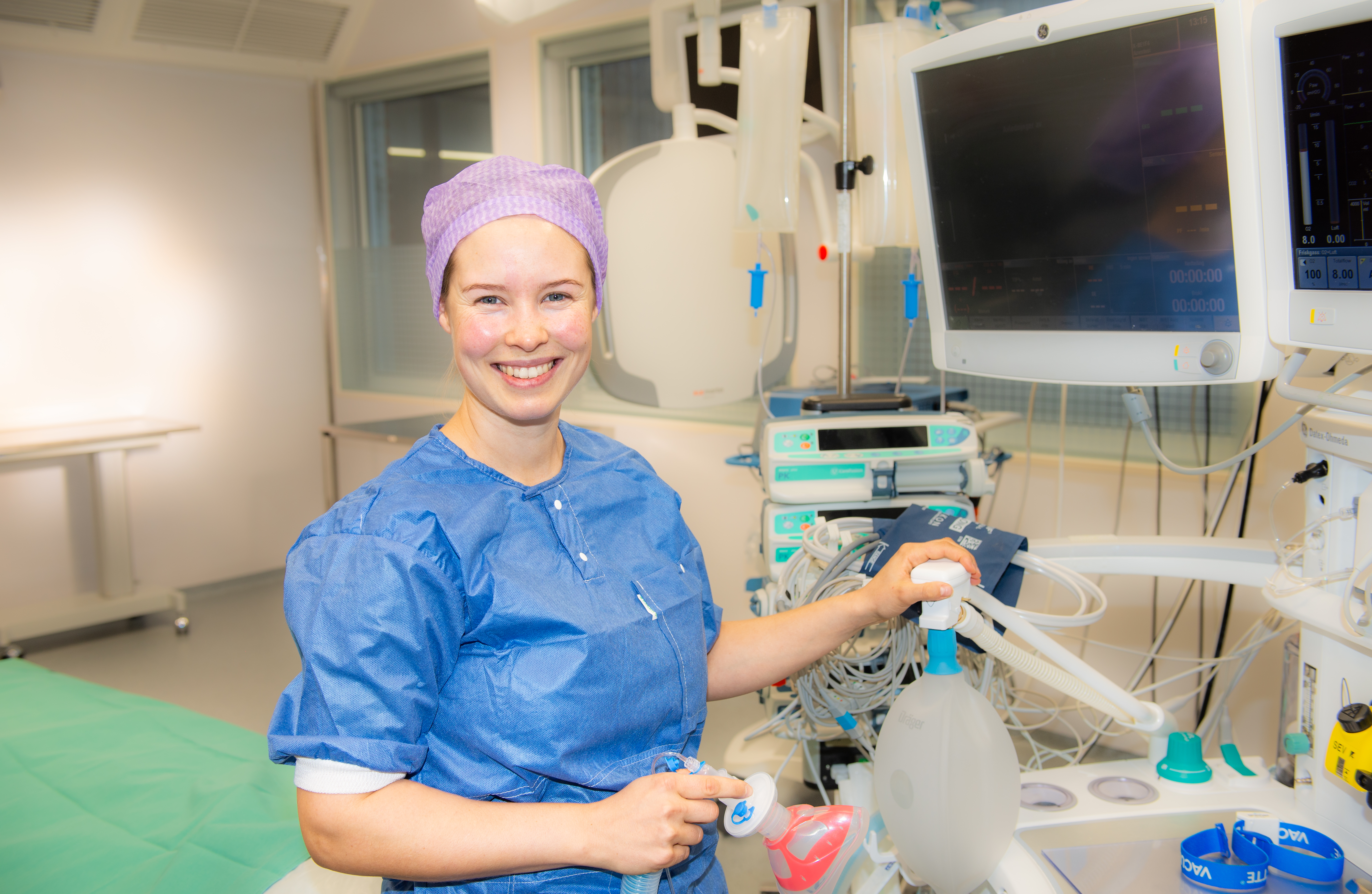 Dame står inne i operasjonssal med masse utstyr.