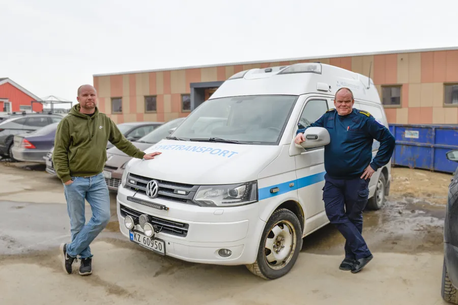 To menn lener seg mot en ambulanse