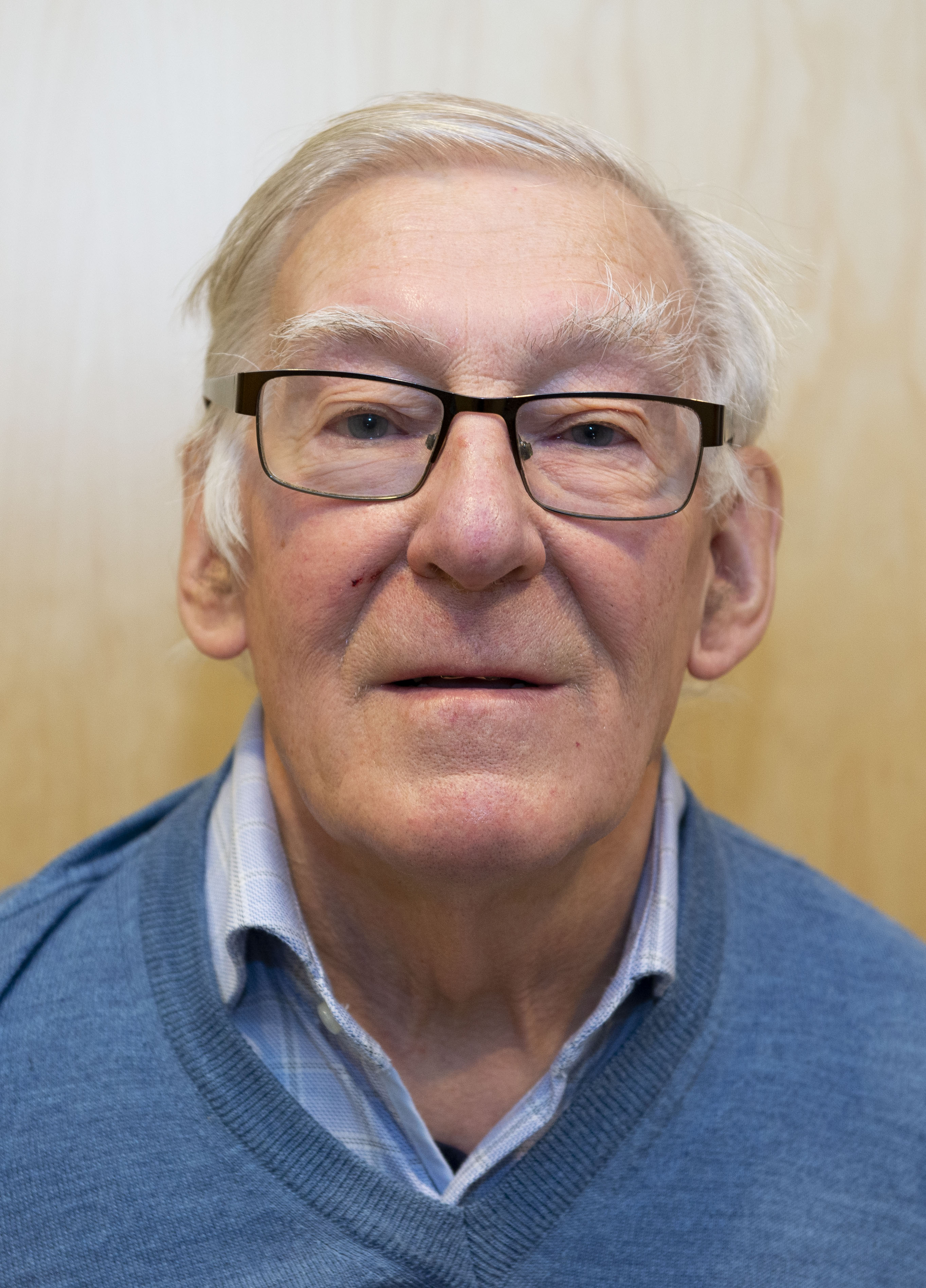 Eldre mann med hvitt hår og briller