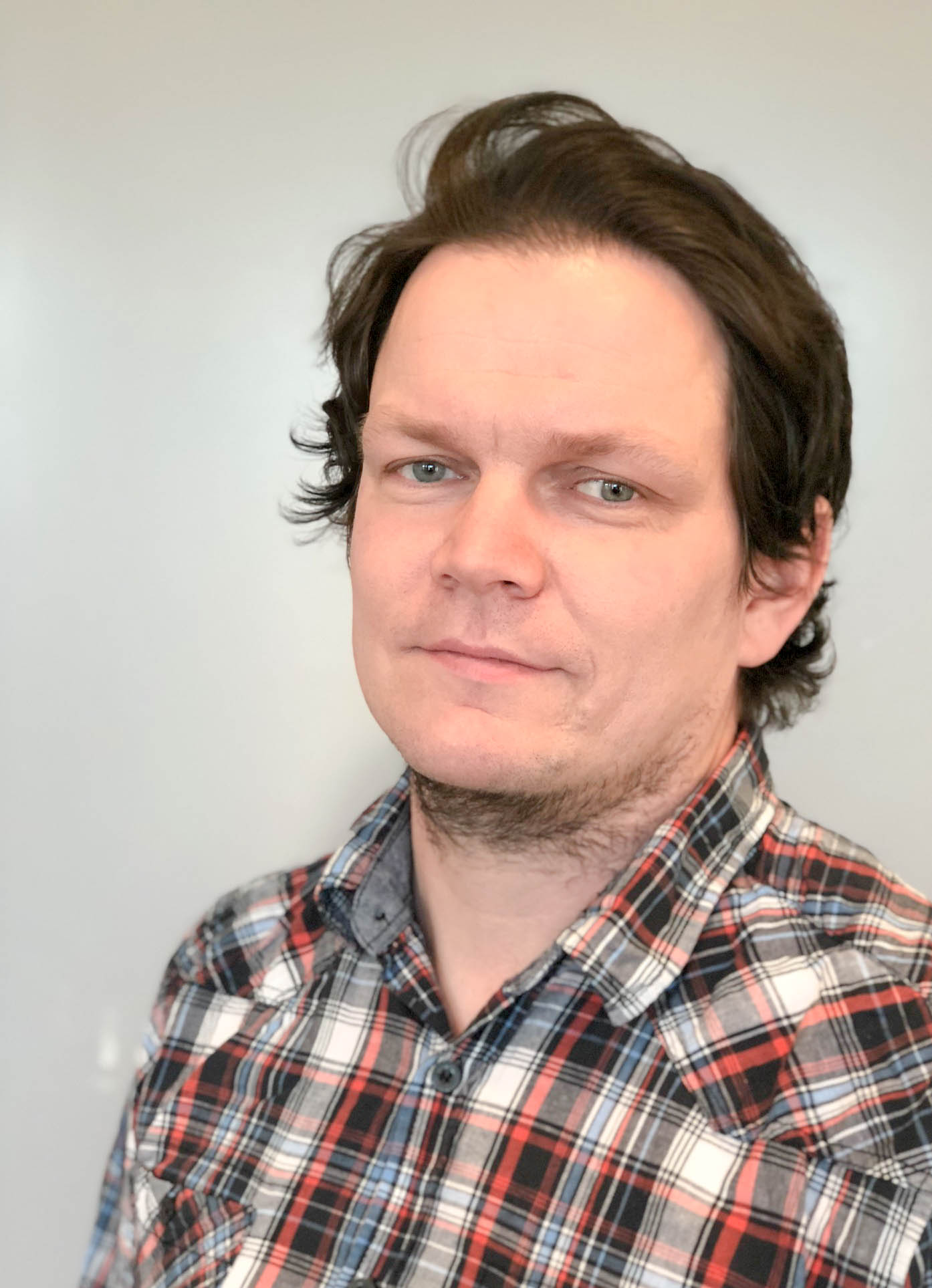 Middelaldrende mann med mørk bloond hår og rutete skjorte