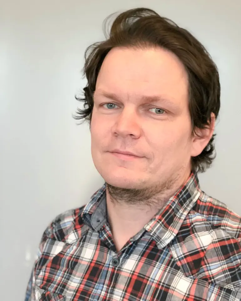Middelaldrende mann med mørk bloond hår og rutete skjorte