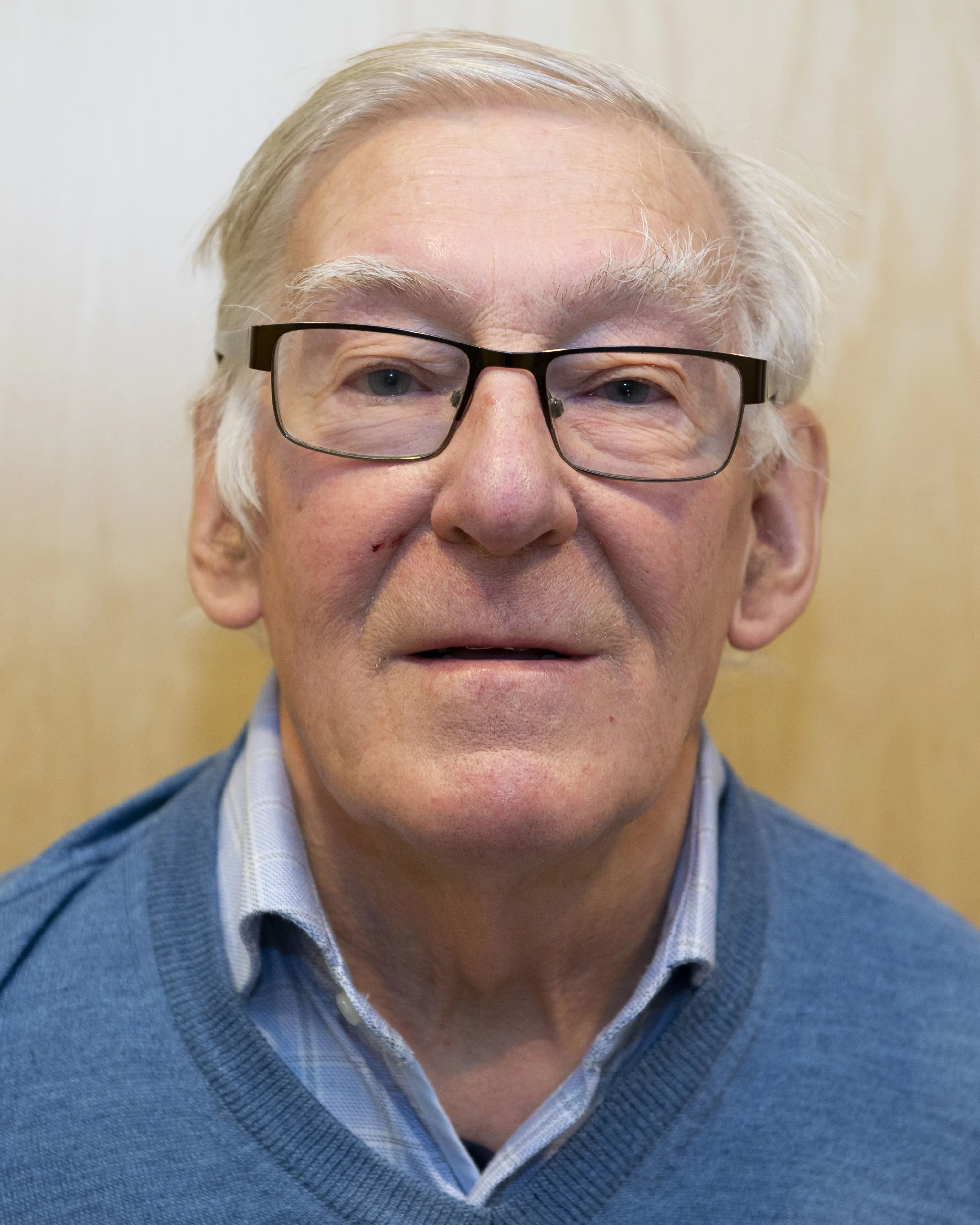 Eldre mann med briller og grått hår