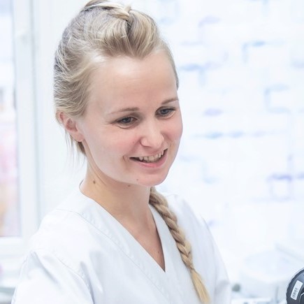 En kvinne som smiler til kameraet