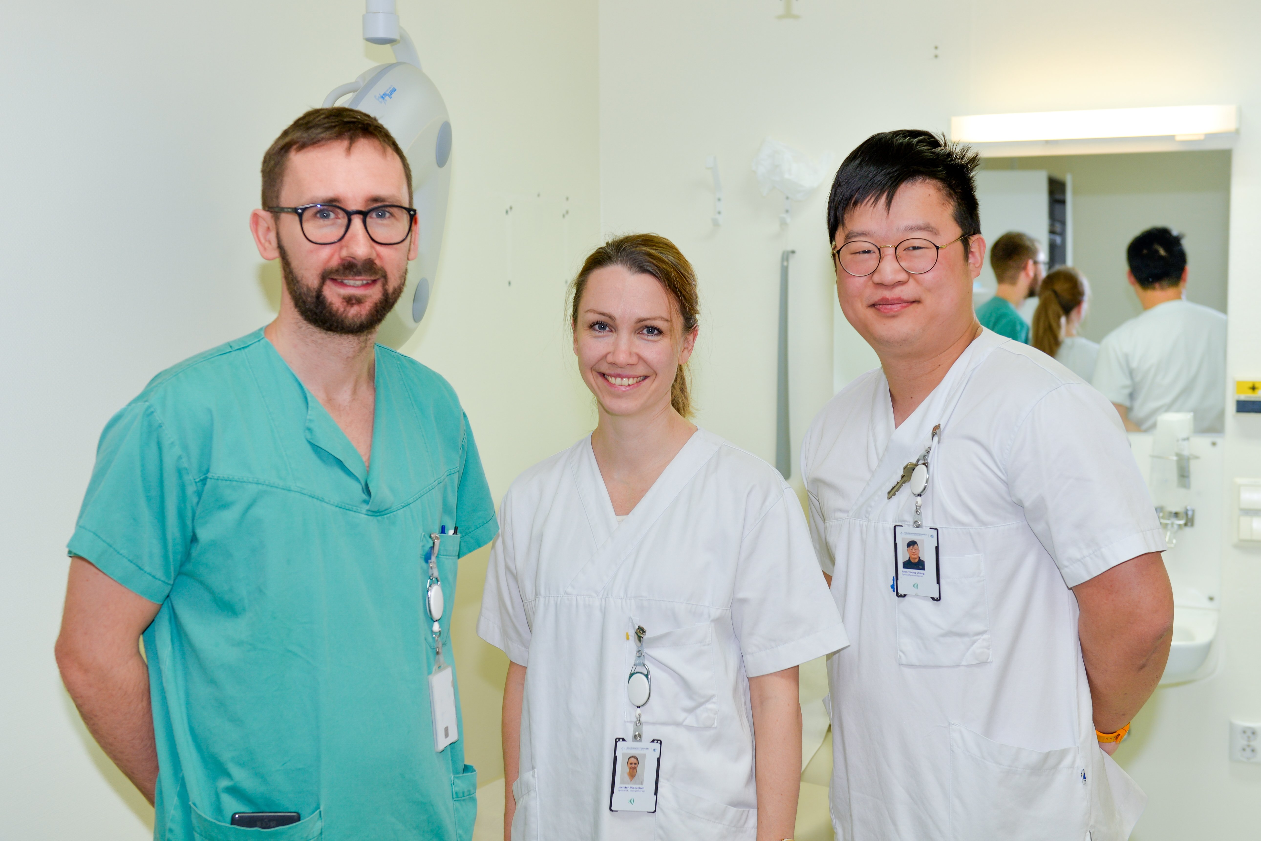 To fysioterapeuter og en ortoped ser i kamera.