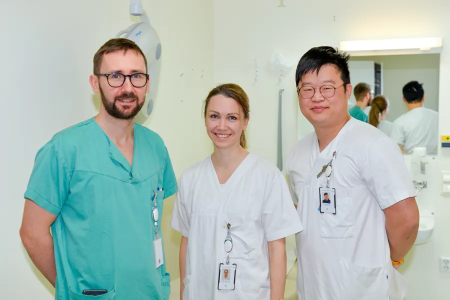 To fysioterapeuter og en ortoped ser i kamera.