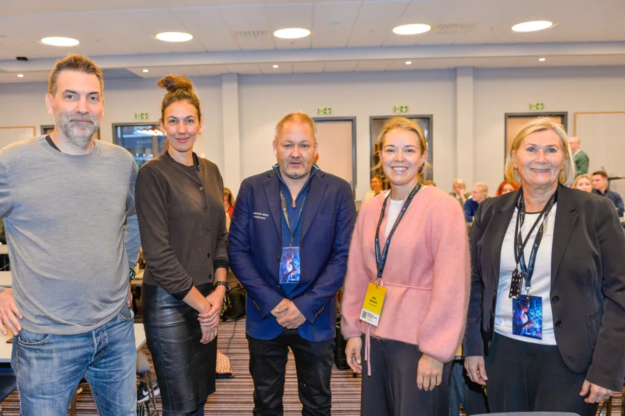 Tre kvinner og to menn står oppstilt og ser inn i kamera