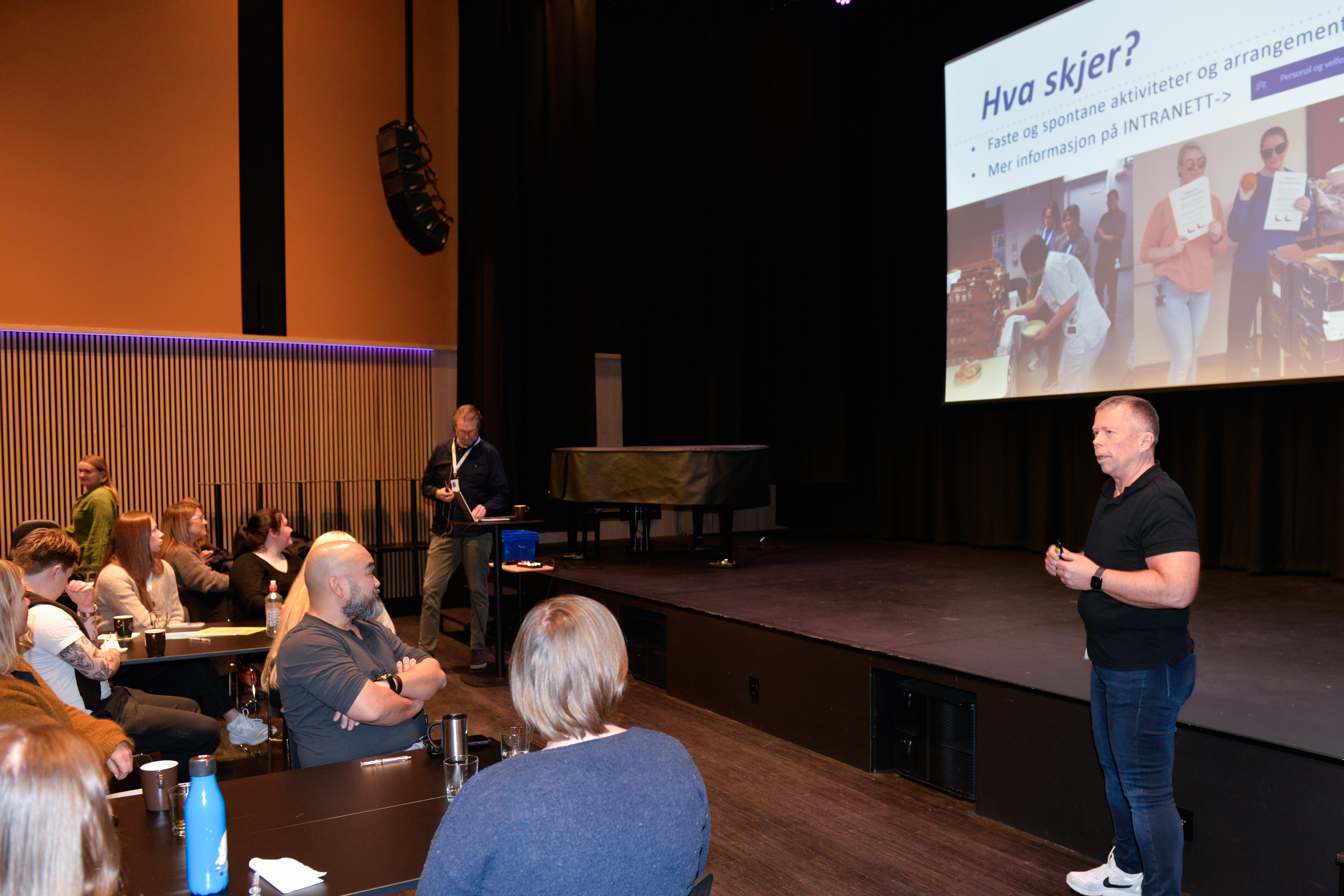 Mann snakker foran ei forsamling