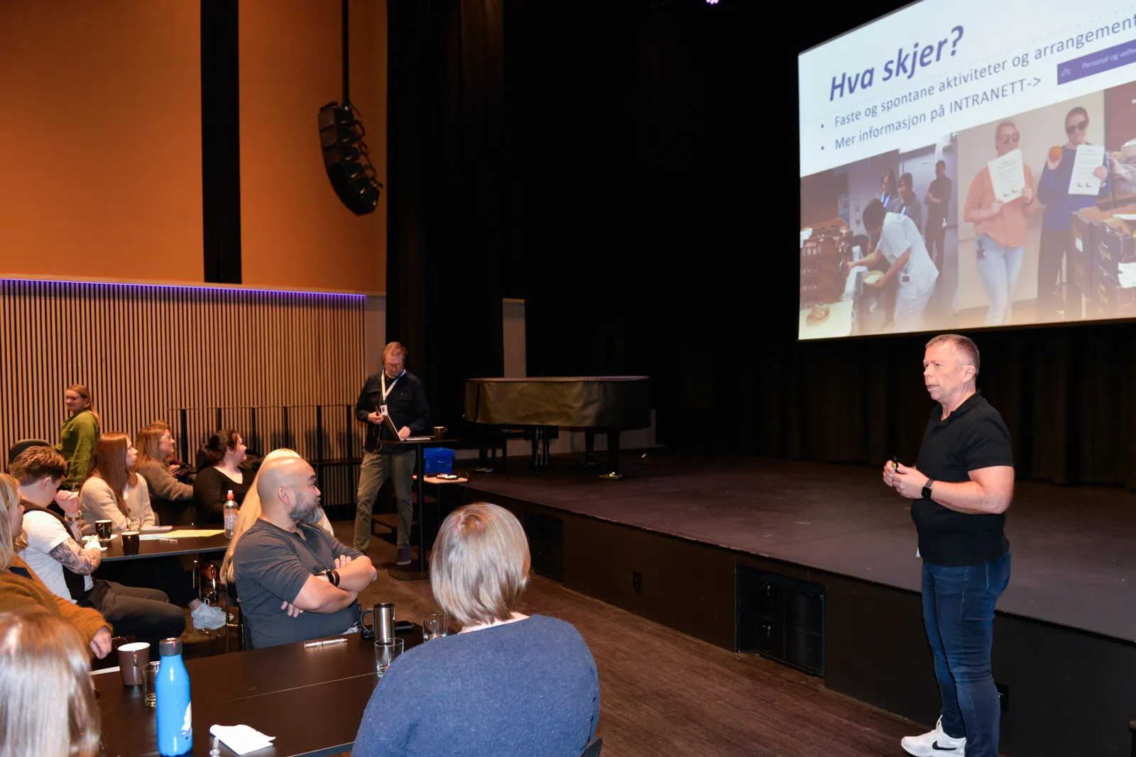 Mann snakker foran ei forsamling