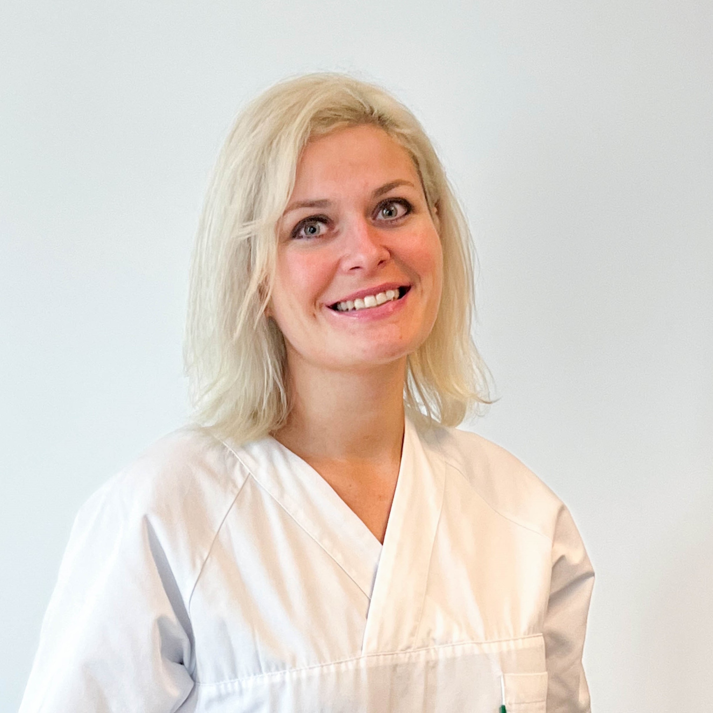 En kvinne som smiler til kameraet