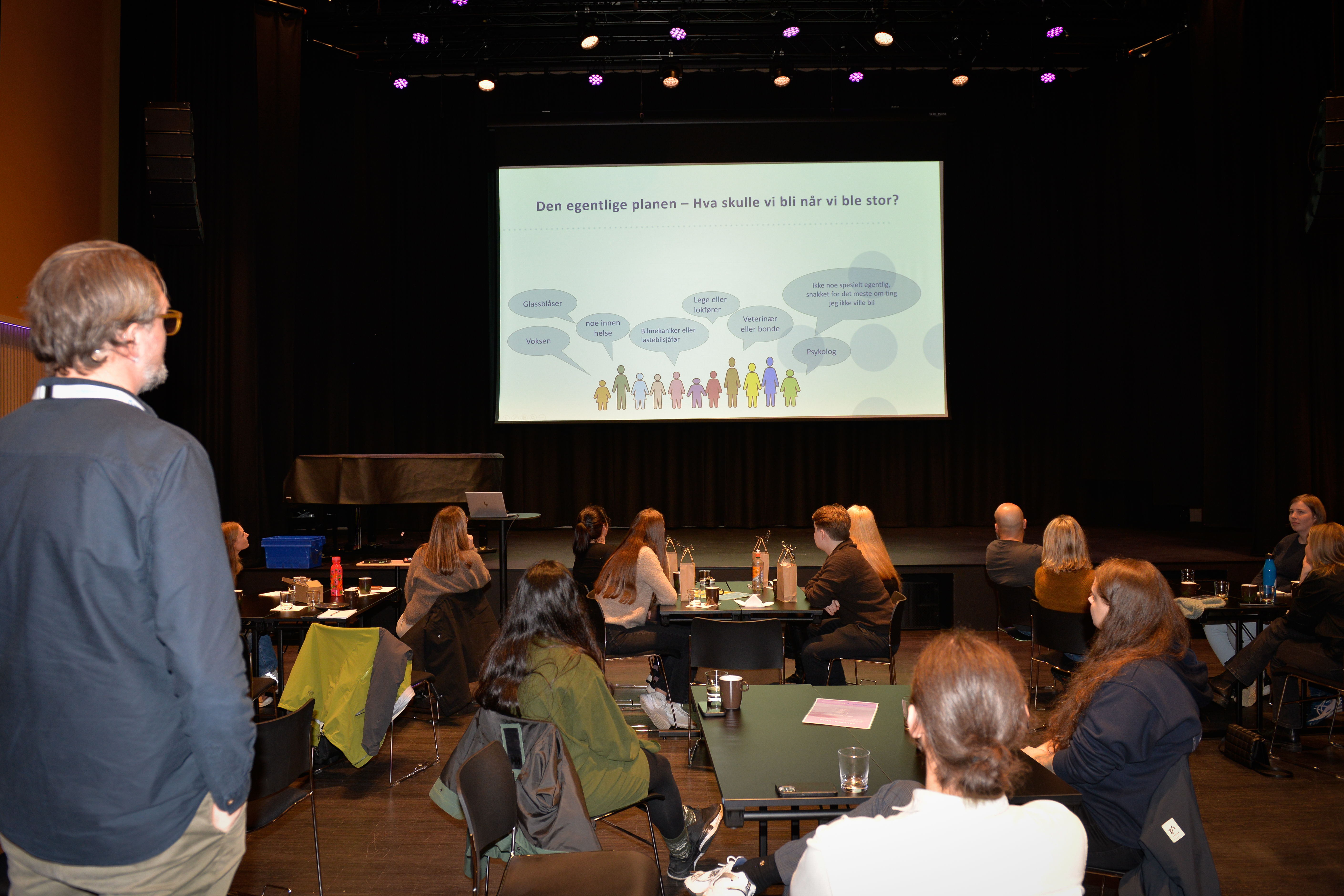 Mange personer ser på en stor skjerm