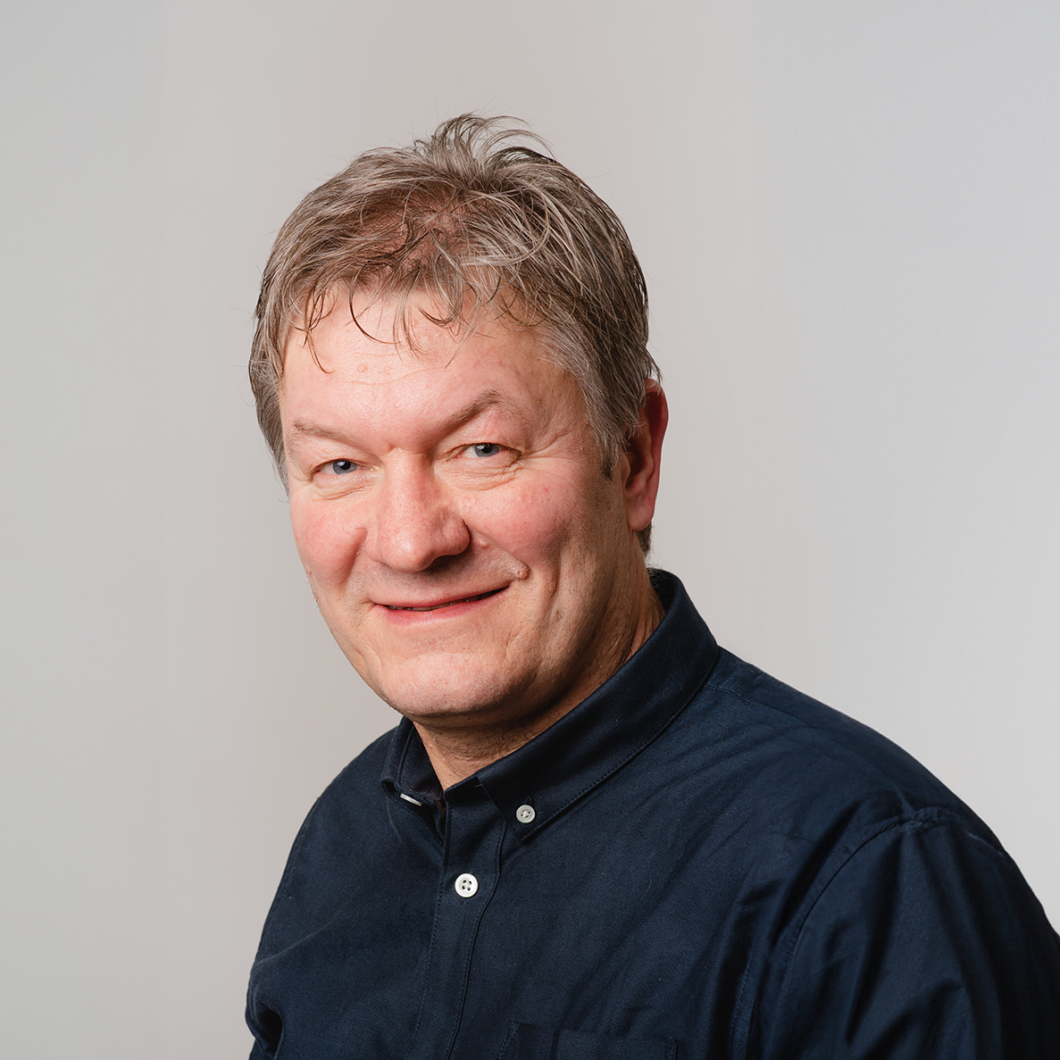 En mann som smiler til kameraet