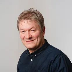 En mann som smiler til kameraet