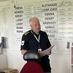 En person i uniform som holder et ark