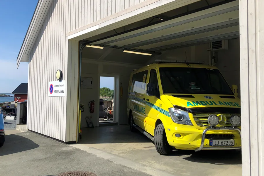 En ambulanse står i en åpen garasje