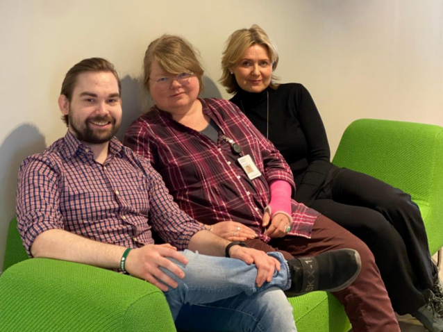 En gruppe mennesker som sitter i en sofa