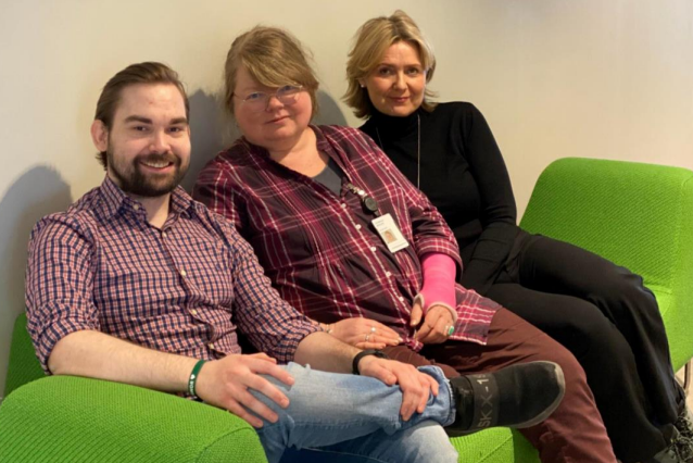 En gruppe mennesker som sitter i en sofa